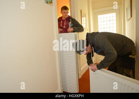Plumbers fitting new radiators in an old house in Aberdeen Scotland Stock Photo