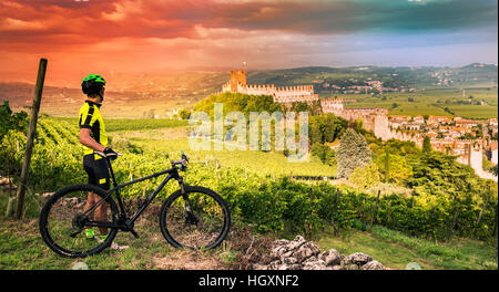 Cyclist admires from the hill the Soave castle views. Stock Photo