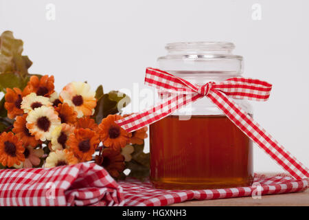 Honey in  jar with honey dipper on a wooden background Stock Photo