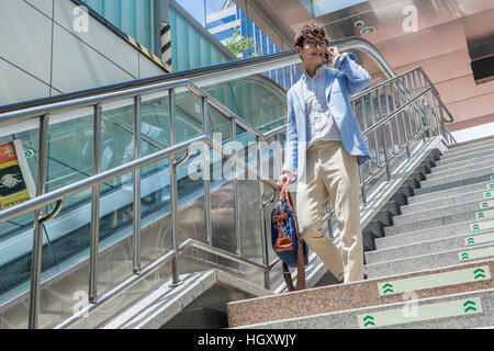Businessman going downstairs talking on cellphone Stock Photo