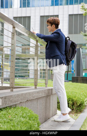 Smiling businessman using smartphone outdoors Stock Photo