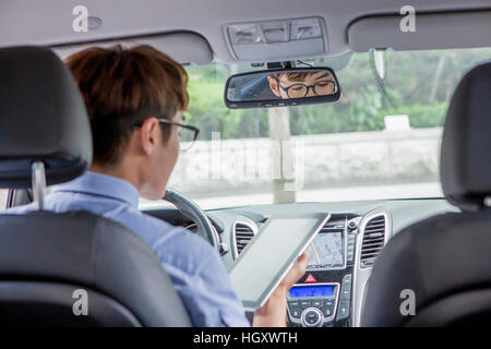 Back of businessman using tablet in a car Stock Photo