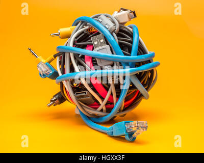 Tangled roll of computer wires over yellow background Stock Photo