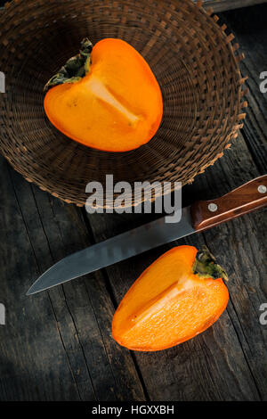 Persimmon fruit on wooden table Stock Photo