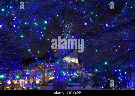 National War Memorial arch called The Response in Ottawa with Chateau Laurier hotel and blue Christmas lights at night Stock Photo