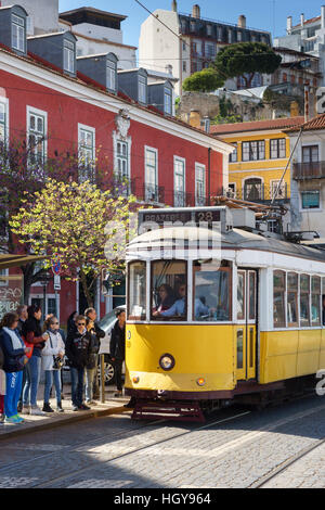 The famous yellow number 28 tram in Lisbon stopping to let passengers board Stock Photo