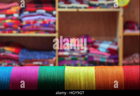 Colored threads on a background of the finished products, tailoring concept. Stock Photo
