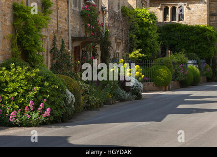 Cotswold stone cottages with colourful roadside floral borders in the village of Stanton, Cotswolds, Gloucestershire, England Stock Photo