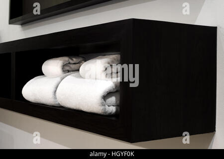white towels on wooden shelf in bedroom Stock Photo