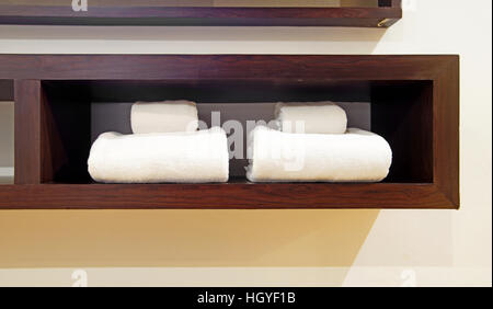 white towels on wooden shelf in bedroom Stock Photo