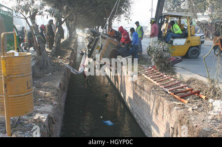 An auto rickshaw strayed off into drain at Sabza Zar area of Lahore on Friday, January 13, 2017. Stock Photo