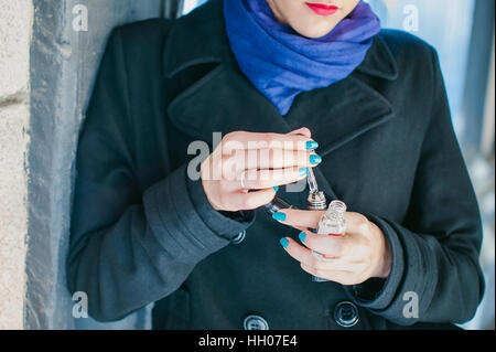portrait of young beautiful woman with white hair, in a black coat, a skirt and a black hat, smoking an electronic cigarette, runs vape juice electron Stock Photo
