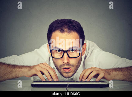 Crazy looking nerdy man typing on the keyboard Stock Photo