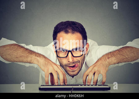 Crazy looking nerdy man typing on the keyboard Stock Photo