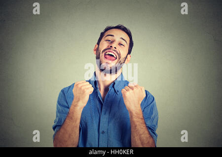 happy successful student, business man winning fists pumped celebrating success isolated gray background. Positive human emotion Stock Photo