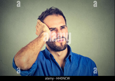 portrait stressed sad handsome young man looking up thinking isolated on gray wall background. Human face expressions emotions. Stock Photo