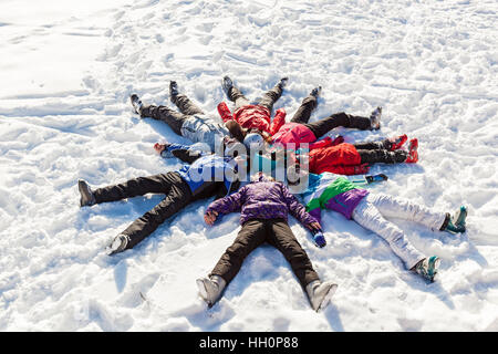 Ukraine Bukovel December 17, 2015  Sun on the snow. Funny family laying on the snow in Bukovel and making a picture of the sun. Stock Photo