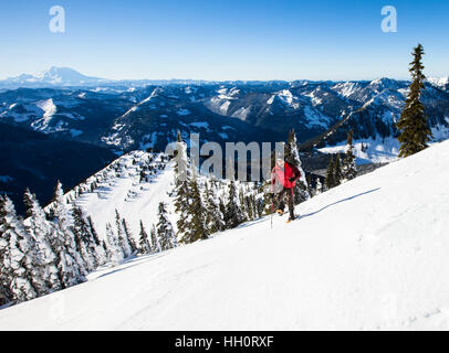 A man snowshoeing up a mountain in the North Cascades Mountains of Washington State Stock Photo