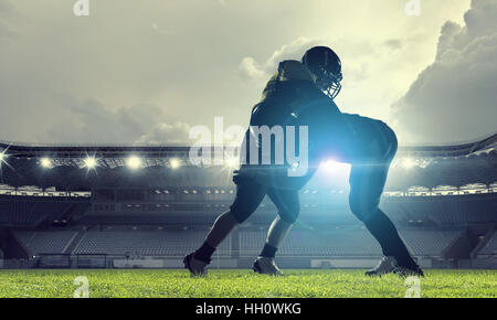 Two american football players fighting for ball. Mixed media Stock Photo