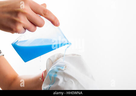 Removing stain from white shirt measuring determent by hand Stock Photo