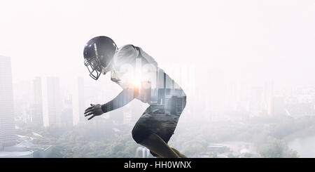 Exposure image of confident American football player against modern city background Stock Photo
