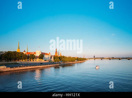 Scenic View To Promenad Of Daugava, In Riga, Latvia. Old Church Towers And Medieval Castle On Background. Seafront Named Ab Dambis. Evening  View With Stock Photo