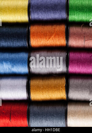 Colorful cotton reels lined up in a row and viewed from above Stock Photo