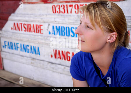 Girl waiting for a taxi brousse minivan transport on the small terminal in Madagascar Stock Photo