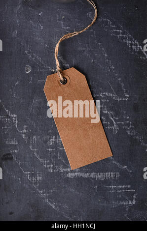 brown paper tag with string on the blackboard Stock Photo