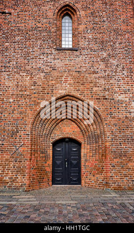 Entrance to Elsinore Cathedral with a black painted double wood door at the bottom of the tower built of red bricks Stock Photo
