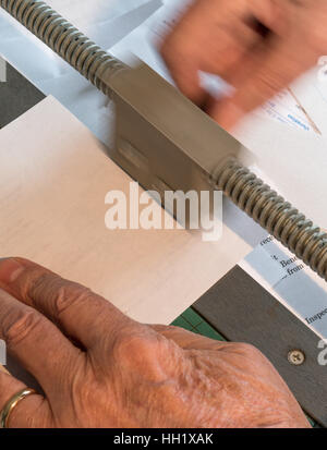 Worker Cutting Paper with a Rotat=ry Paper Trimmer Stock Photo