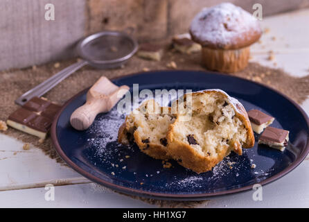 Muffins sprinkled by powdered sugar on white wooden desk. Stock Photo