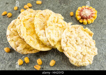 circle shaped corn snacks and corn kernels Stock Photo