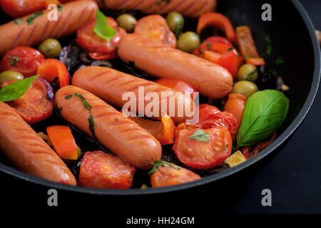 Sausages grilled with vegetables in the Greek style on pan. Stock Photo