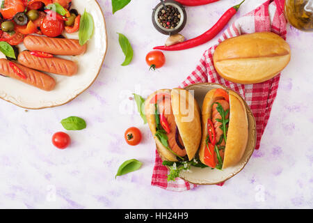Hot dog with sausage and vegetables in the Greek style. Flat lay. Top view Stock Photo
