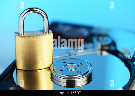 Gold padlock on the opened HDD disk drive surface. Data protection or security concept Stock Photo