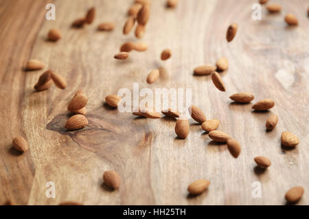 peeled almonds spread on old wooden table Stock Photo