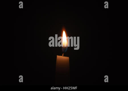 tall candle blown in the dark environment Stock Photo