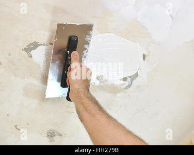 Troweling spackle on ceiling with finishing trowel Stock Photo