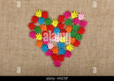 Heart of human hand palm shaped handmade colorful multicolor wooden painted sewing buttons on linen canvas, elevated top view Stock Photo