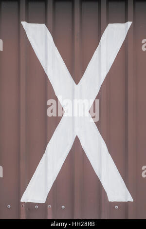 White letter X painted on a brown background Stock Photo