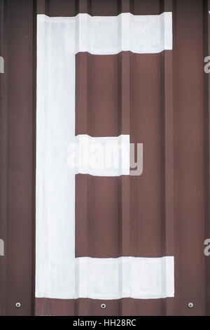 White letter E painted on a brown background Stock Photo