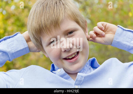 Cute blond boy in autumn yellow forest Stock Photo