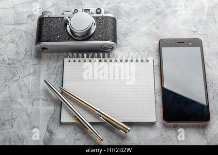 Notebook mock up for artwork with film camera and smartphone. Top view. Stock Photo