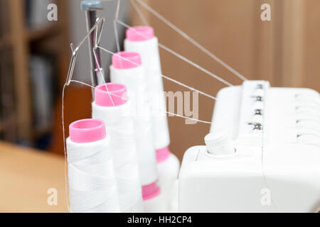 Yarn rolls on an overlock sewing machine Stock Photo
