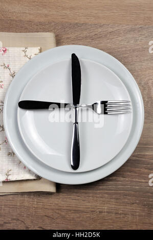 Dining etiquette - I still eat, ready for second plate. Fork and knife signals with location of cutlery set Stock Photo