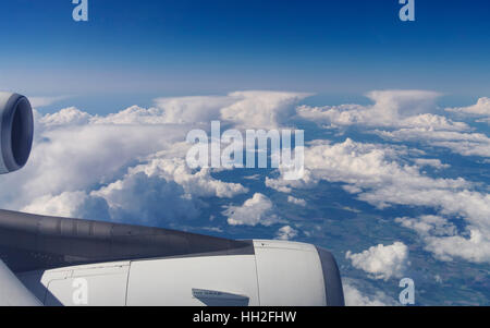 View out of an airplane over a row of anvil-shaped cumulonimbus clouds. Stock Photo