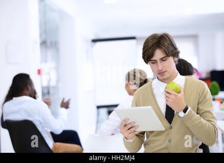 Portrait of confident businessman using digital tablet while colleague in background Stock Photo