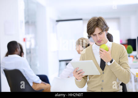 Portrait of confident businessman using digital tablet while colleague in background Stock Photo