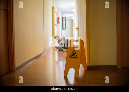 Man slips on wet floor Stock Photo